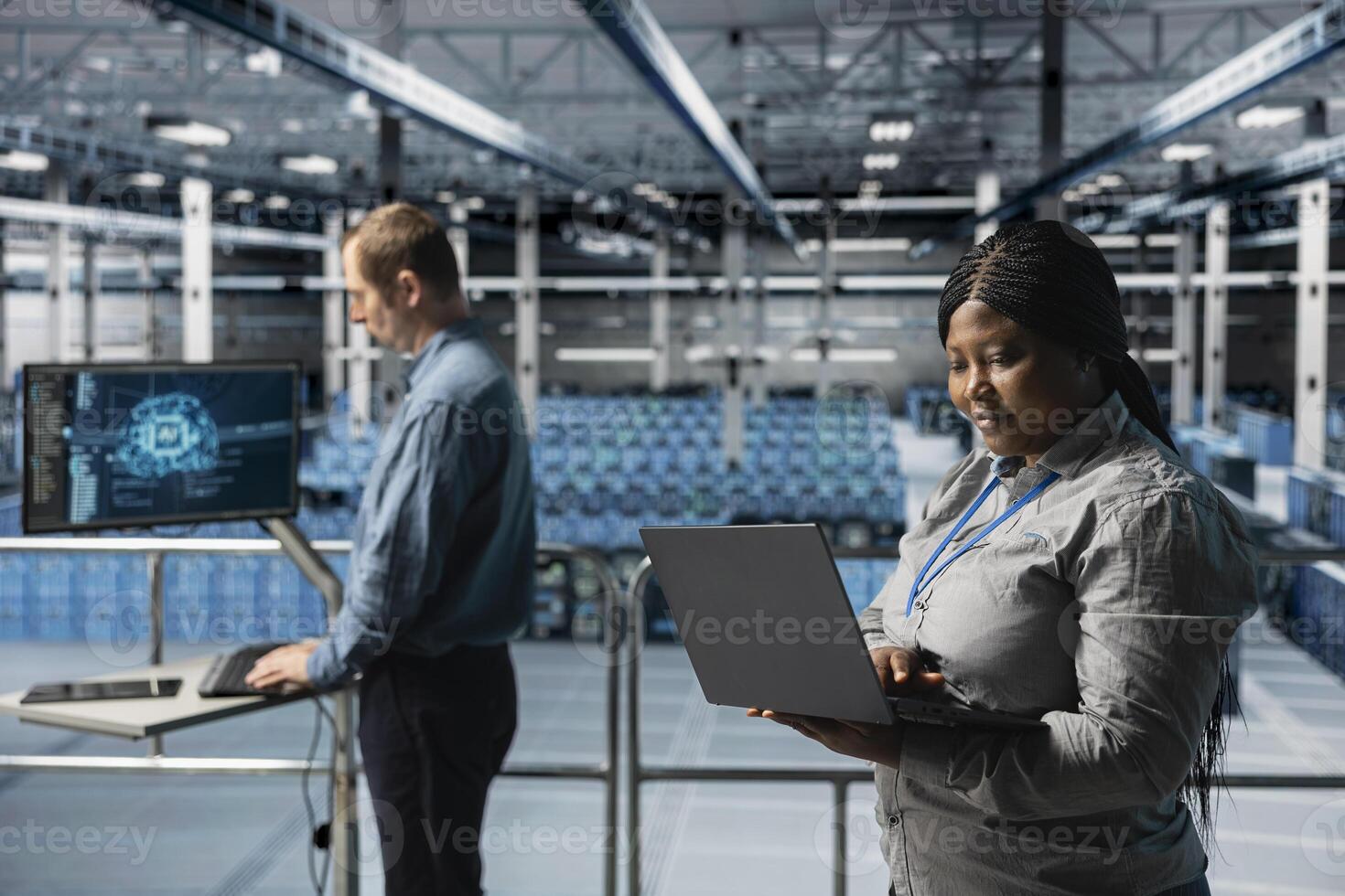 Server farm teamworking admins using laptop to do infrastructure AI machine learning automatization. Data center software developers doing maintenance using artificial intelligence photo