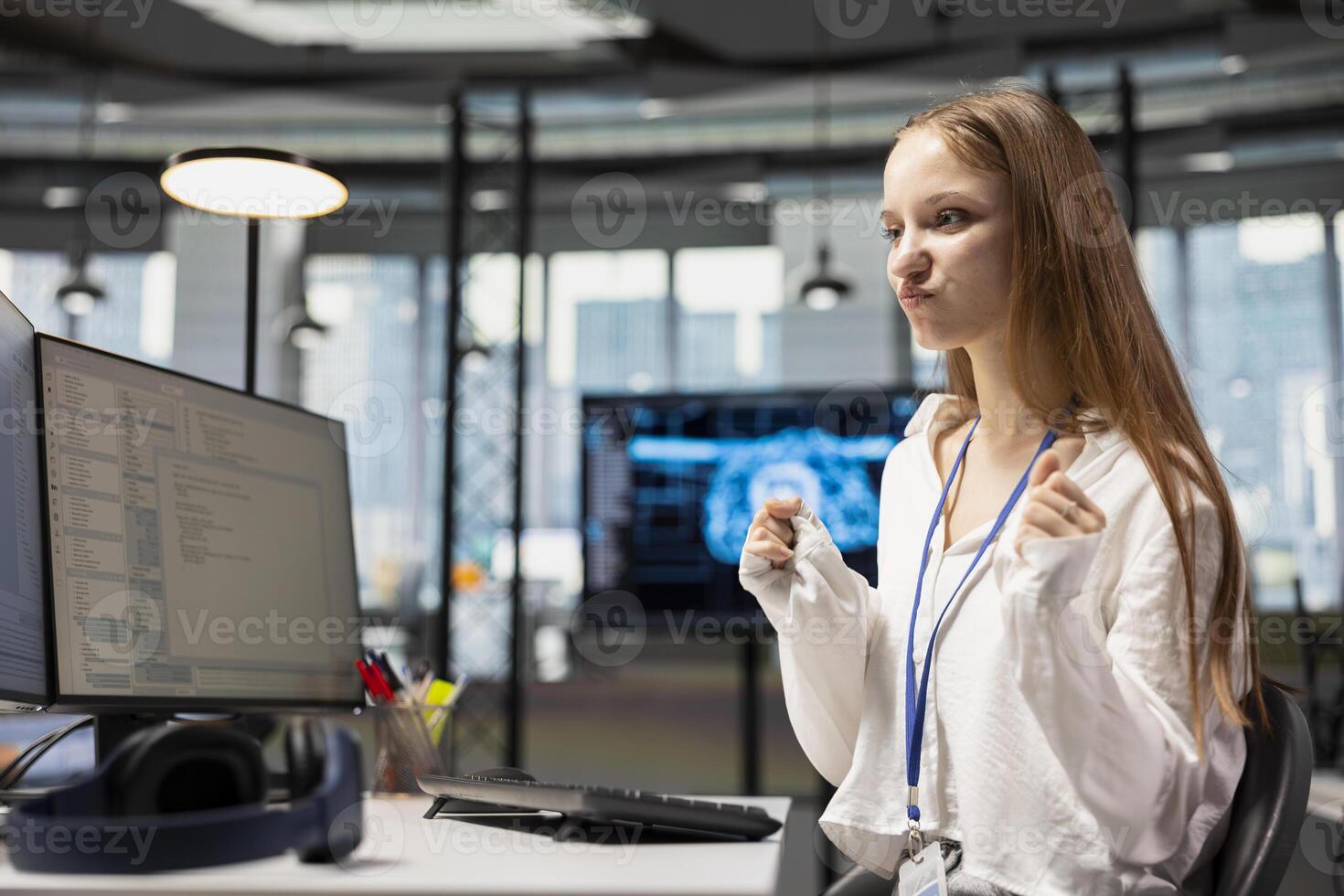 Joyous female technician celebrating after automating tasks using deep learning algorithms at work. Delighted young girl pleased after using AI driven insights for code optimization photo