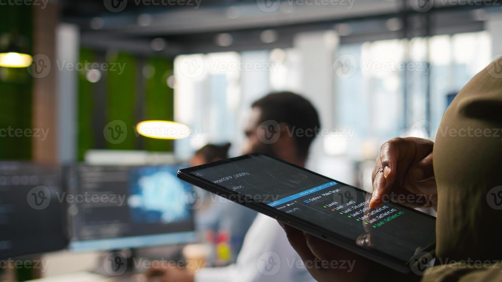 Close up of programmer utilizing AI on tablet to optimize performance and forecast issues. System administrator in office training machine learning models using device, camera A photo