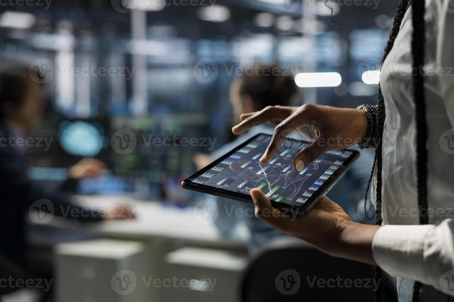 Close up of data center programmer monitoring AI systems using tablet, adjusting machine learning parameters. Server farm worker enhancing artificial intelligence technology performance with device photo