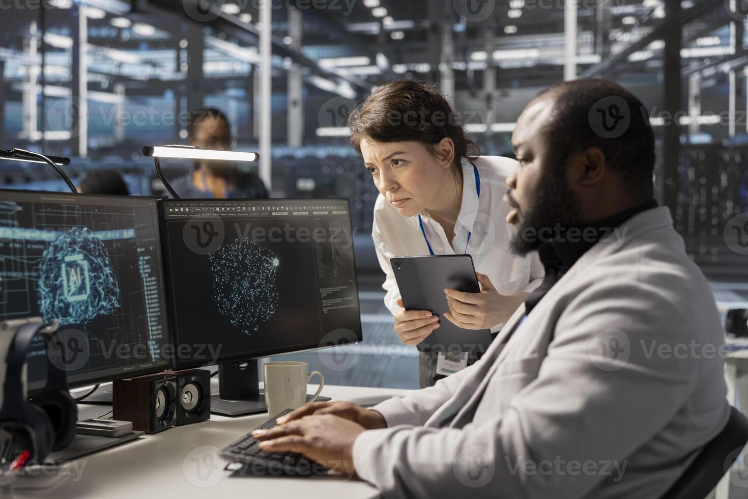 Manager supervising programmer in data center using AI powered tech to run simulations. Supervisor overseeing work done by IT expert coding cognitive computing algorithms to automate rigs photo