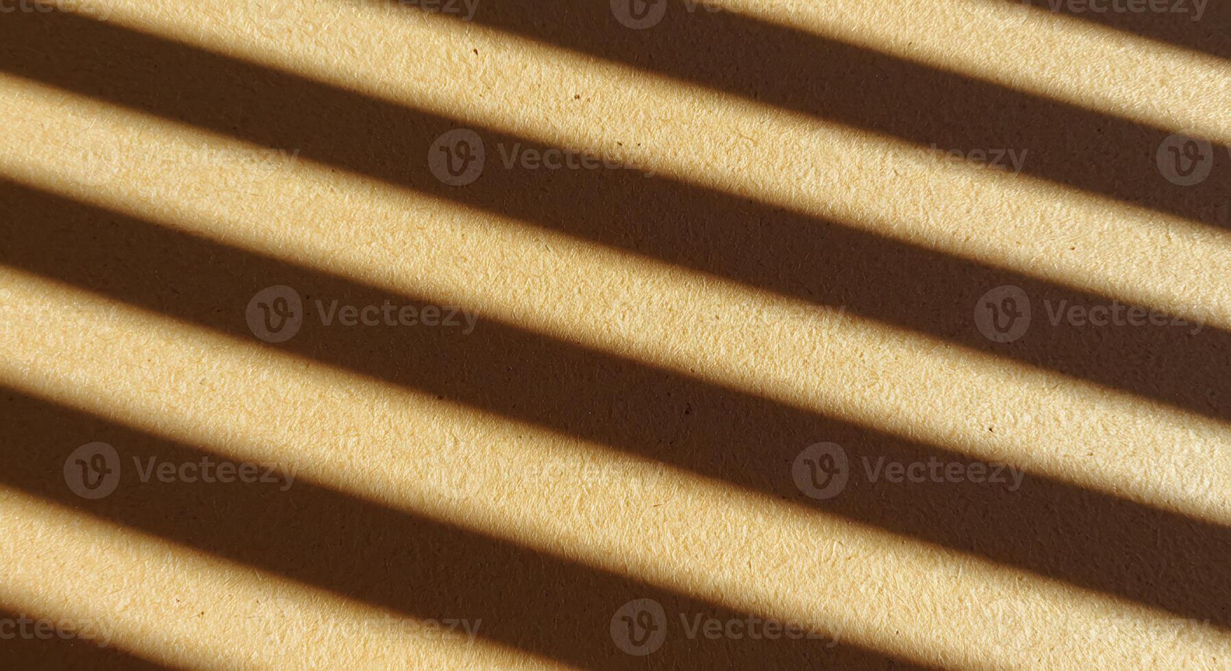 Golden Light and Shadow Stripes Creating a Rhythmic Diagonal Pattern on Textured Paper photo