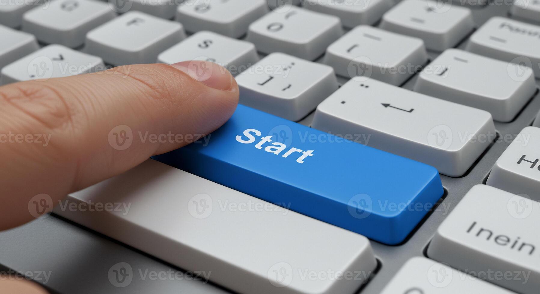 A person is pressing the start button on a computer keyboard photo