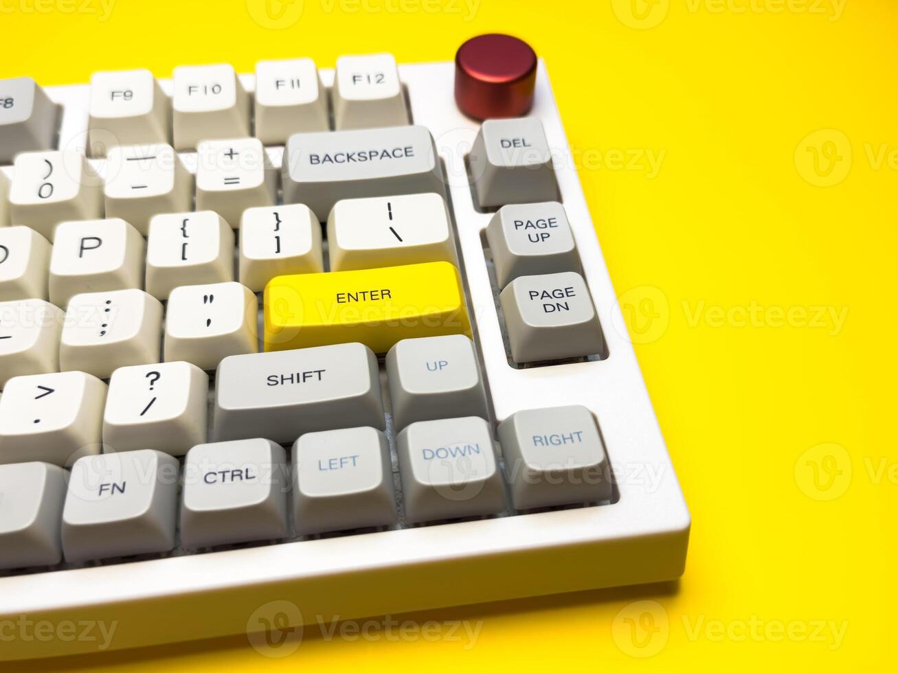 keyboard with bright Enter key on bright yellow background, minimalism, keyboard buttons. A keyboard with a yellow key on the bottom left photo