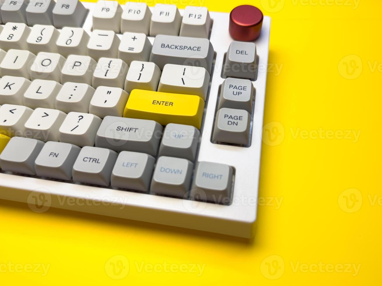 White mechanical keyboard with bright Enter key on bright yellow background, minimalism, keyboard gray color photo