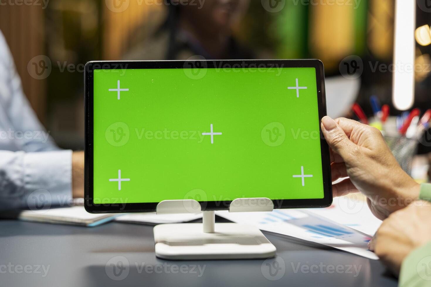 Close up of business team hosting a meeting with chroma key on tablet, late night briefing conference to discuss budget updates and performance metrics. Align company objectives for vision. photo