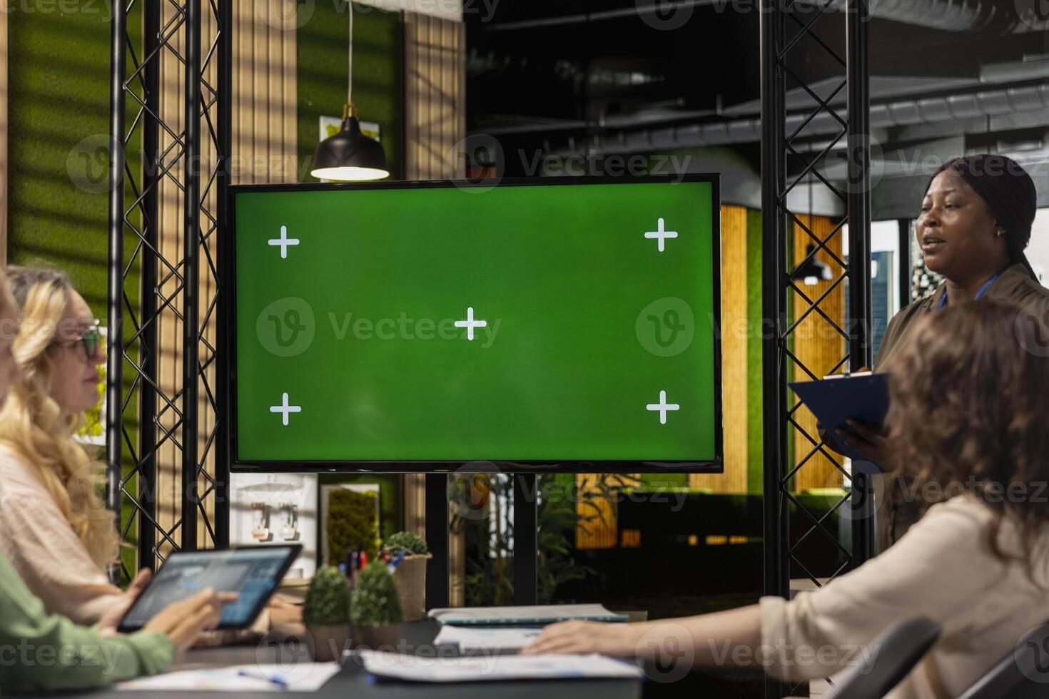 Group of business partners reviewing project analytics with green screen, empowered by data and team collaboration. Female office colleagues reviewing digital content, graphs or reports. photo