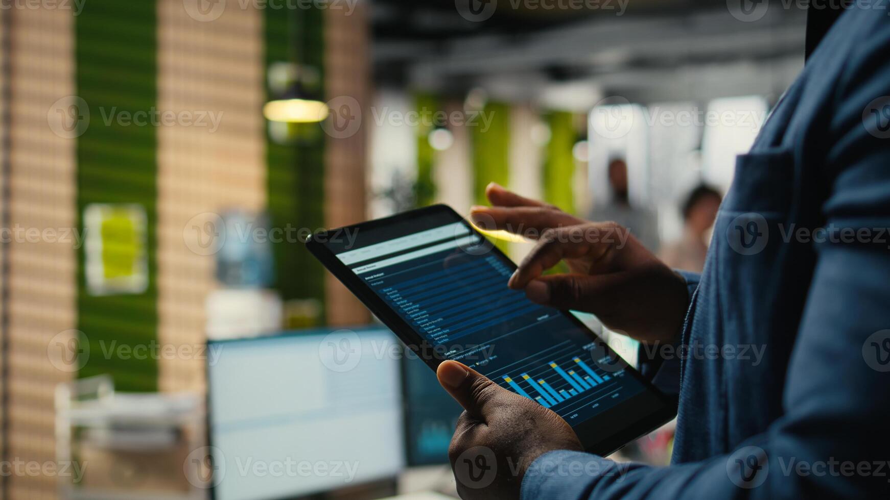 Close up of black employee engages in charts analysis session on tablet, leveraging data insights and reports to align the business strategy with goals for efficient project execution. photo
