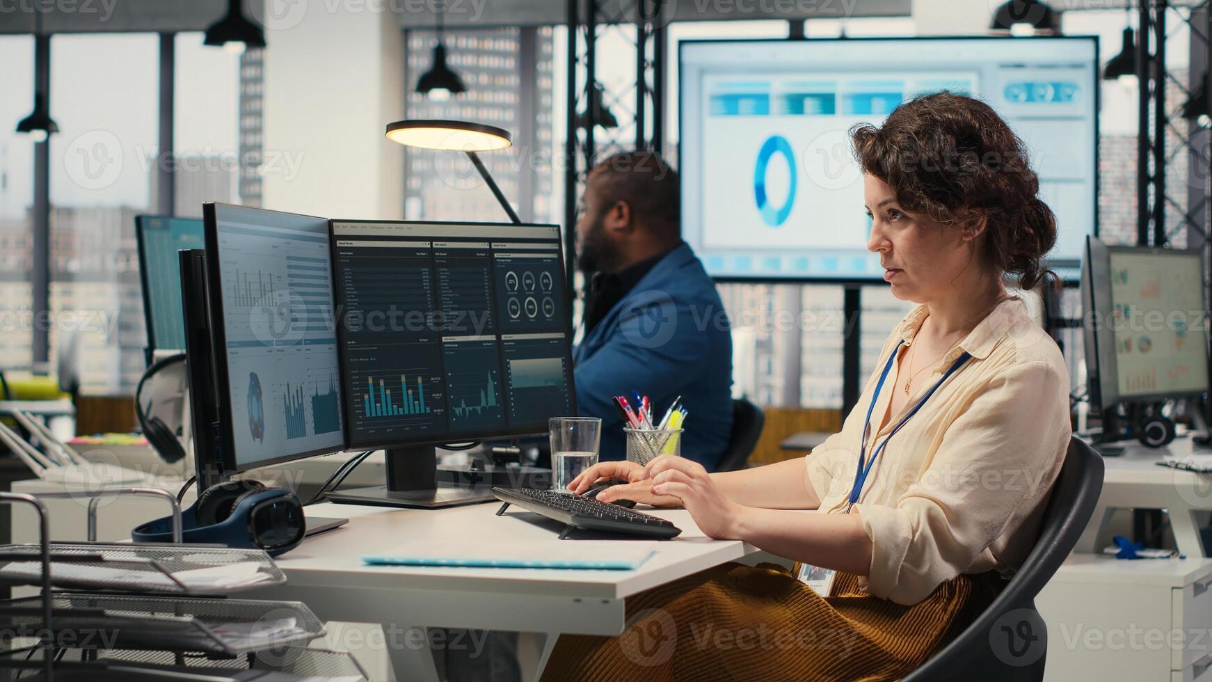 Female business analyst leverages insights and report writing for forecast results and corporate development, utilizing financial data charts for strategic alignment with objectives. Camera B. photo