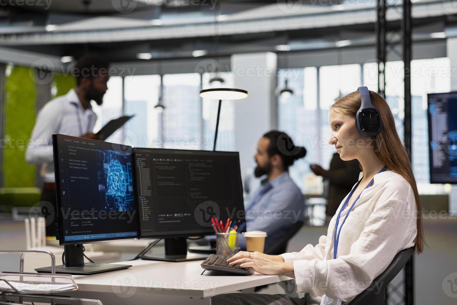 Smiling junior dev in tech startup utilizing AI to optimize performance while listening music. Upbeat female engineer wearing headphones writing code in office, training machine learning models photo