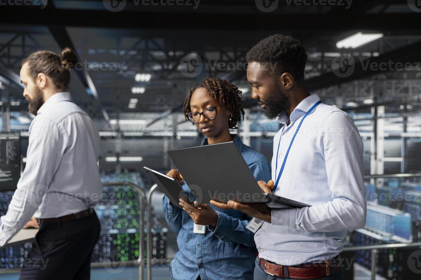 Black engineering team doing maintenance on servers used for AI processing. IT experts managing data center arrays to guarantee machine learning automation on laptop, visual analytics. photo