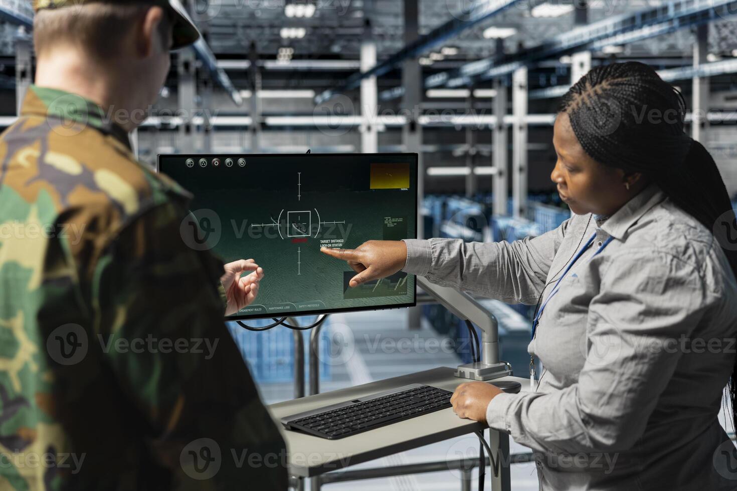 Army information expert talking with commander in data center, showing crosshairs locking onto enemy targets. Military server hub engineer discussing with officer, showing tactical software screen photo