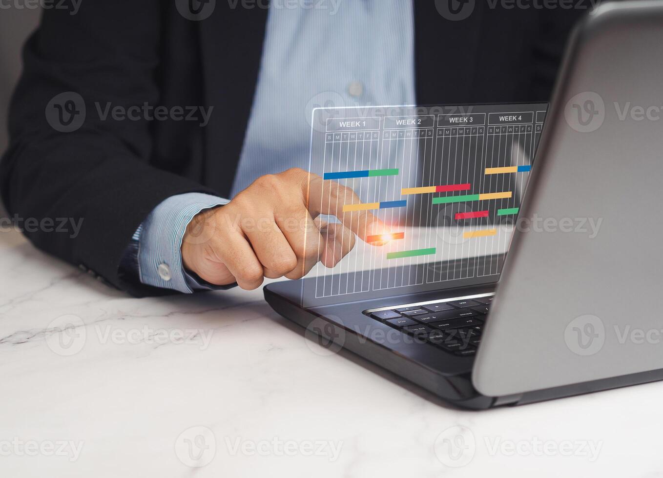 Close-up of a project manager working on a laptop and updating tasks and milestones progress planning. photo