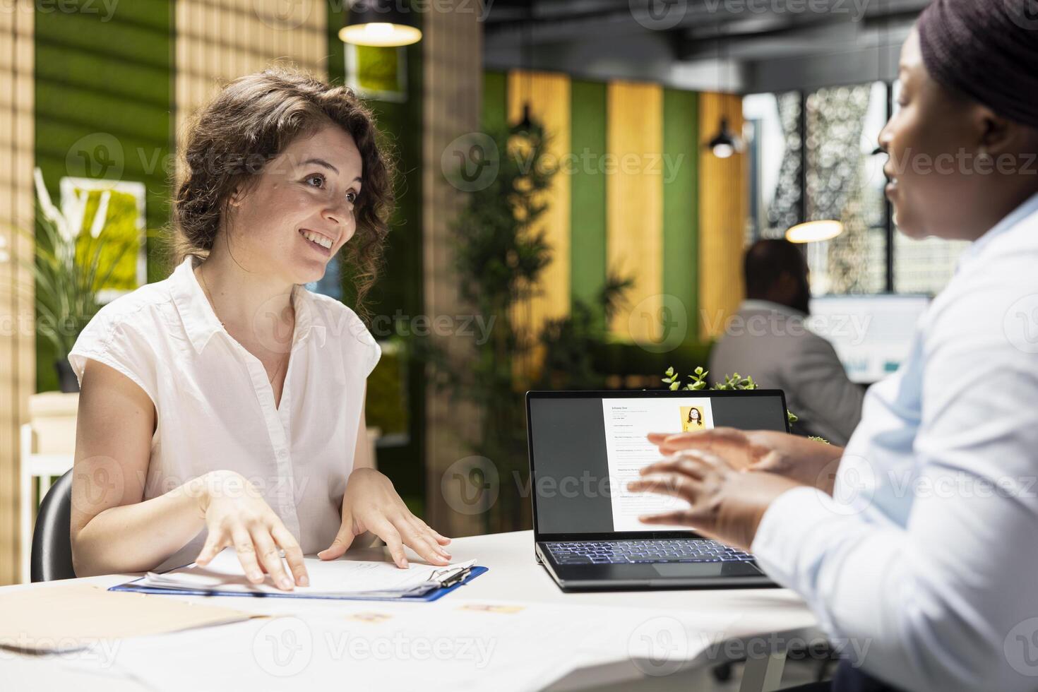 Excited applicant reviews work terms on document and adds signature during a meeting within the HR department, finalizing employment terms and preparing to start a new business position. photo
