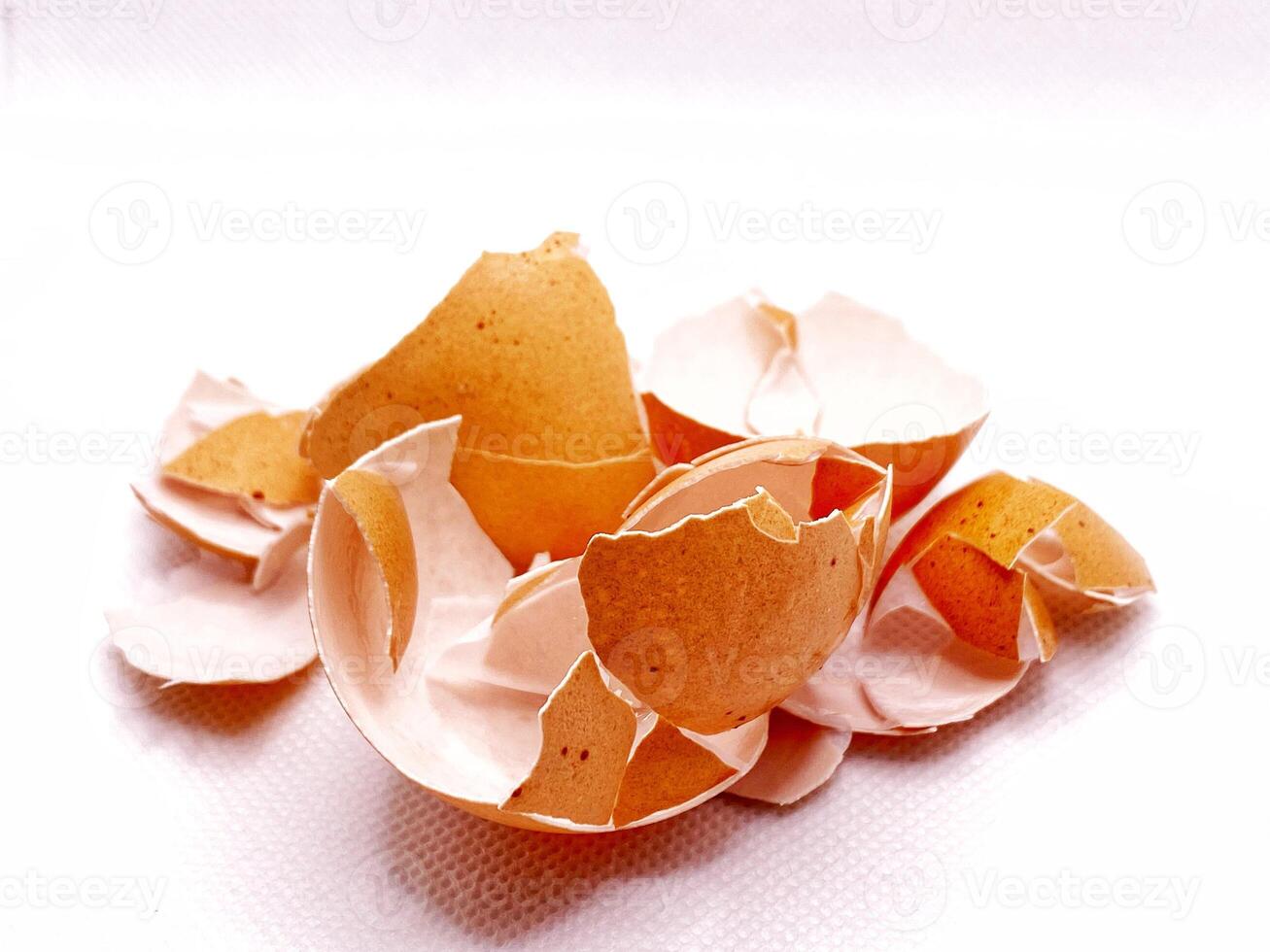 Cracked eggshells create a delicate abstract pattern on a bright white textured . photo