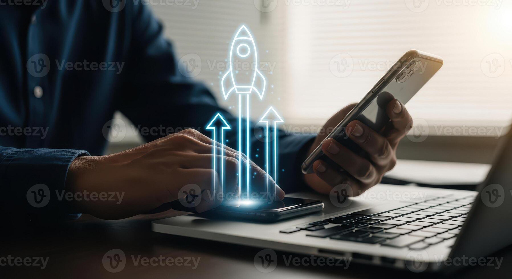 Businessman using smartphone and laptop with a rocket launch graphic symbolizing growth photo