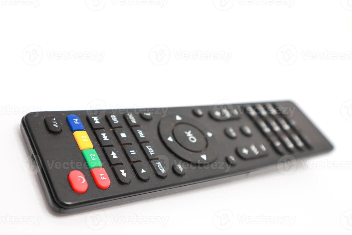 A black remote control device with various colorful buttons on a white surface photo