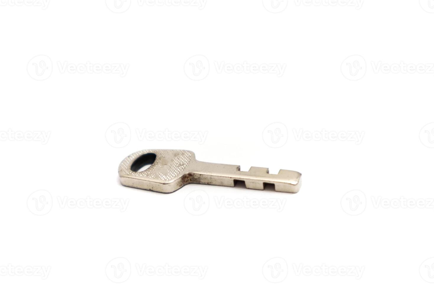 Close-up shot of a silver-colored key on a white background, showcasing its intricate design and functionality photo