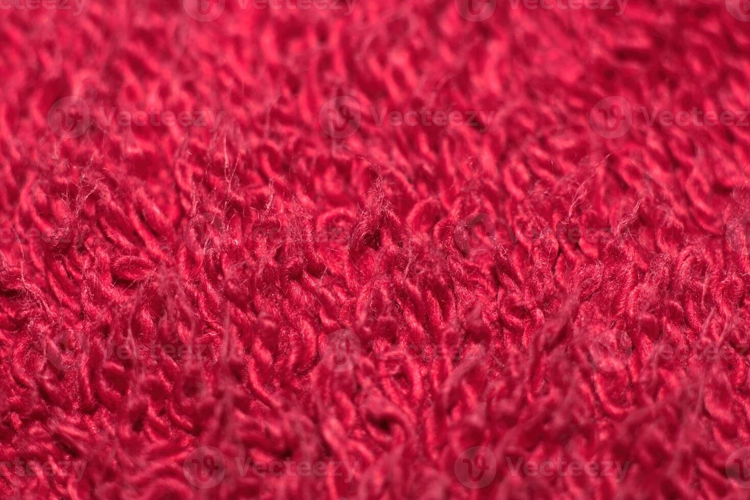 Close-Up Of A Red Towel Texture. A macro, slightly low-angle shot of a red towel, capturing the detailed texture of its looped terry cloth weave, creating a soft and absorbent-looking surface. photo
