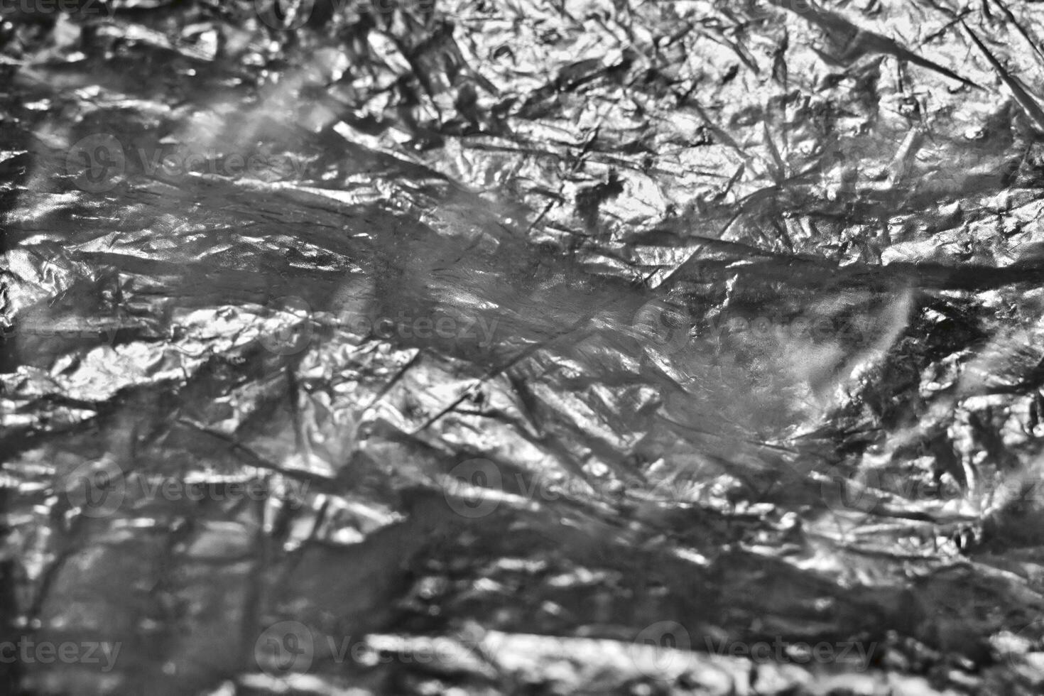 Crumpled aluminum foil texture, close-up view. The intricate details and reflective surface highlight the creases and folds, suitable for backgrounds, textures, and abstract themes. photo