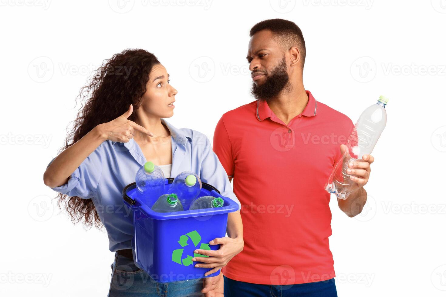 Husband Refusing To Sort Waste Having Quarrel With Wife While She Holding Box With Recycle Symbol And Plastic Litter Standing On White Studio Background. Junk Disposal, Recycling And Trash Sorting photo