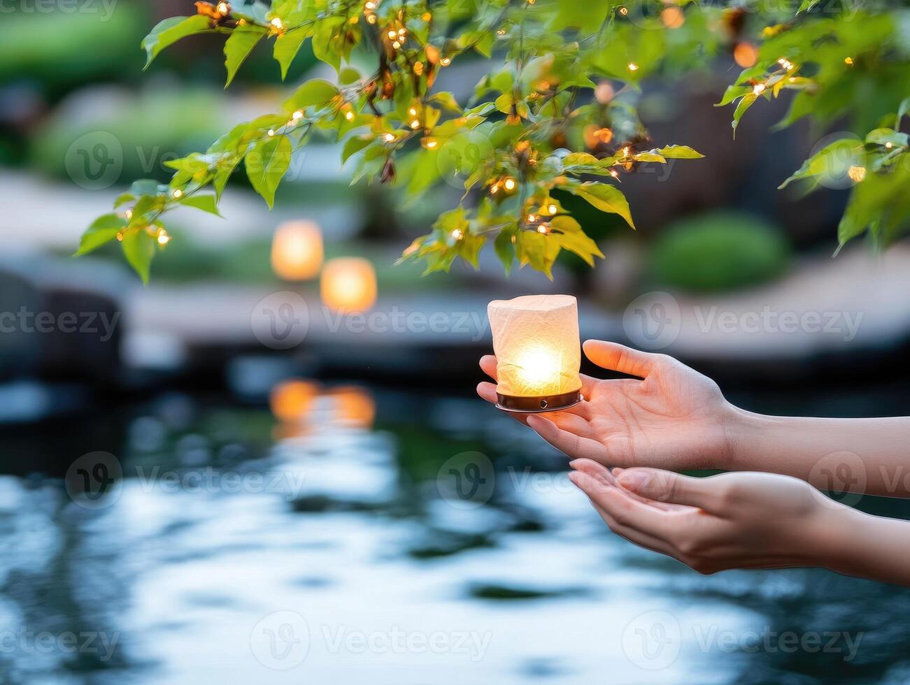 manos participación brillante vela en tranquilo jardín ajuste con borroso luces y agua reflexiones foto