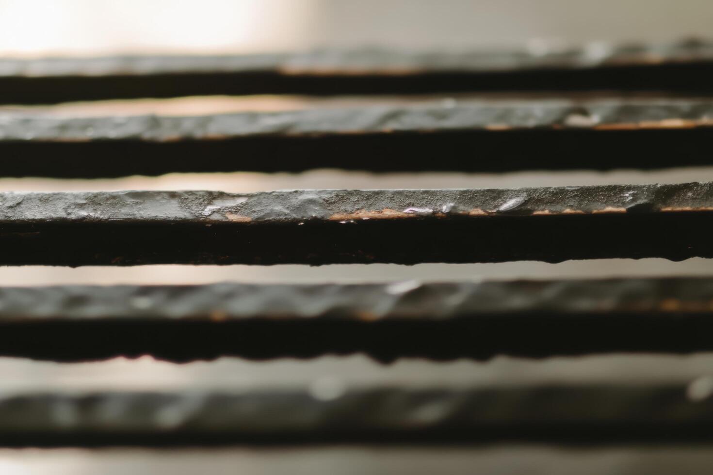 Close-up view of textured metal bars under soft light revealing intricate details and unique patterns photo