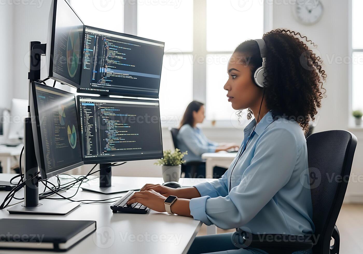Young female software engineer coding on multiple screens in a bright, modern office. Focused woman with headphones working in tech and data analysis. photo