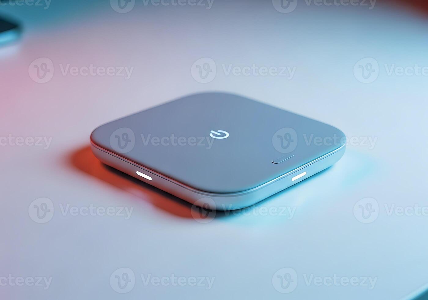 A Sleek Gray Electronic Device With A Glowing Power Button And Indicator Lights, Resting On A Tabletop. Modern Technology And Minimalist Design. photo