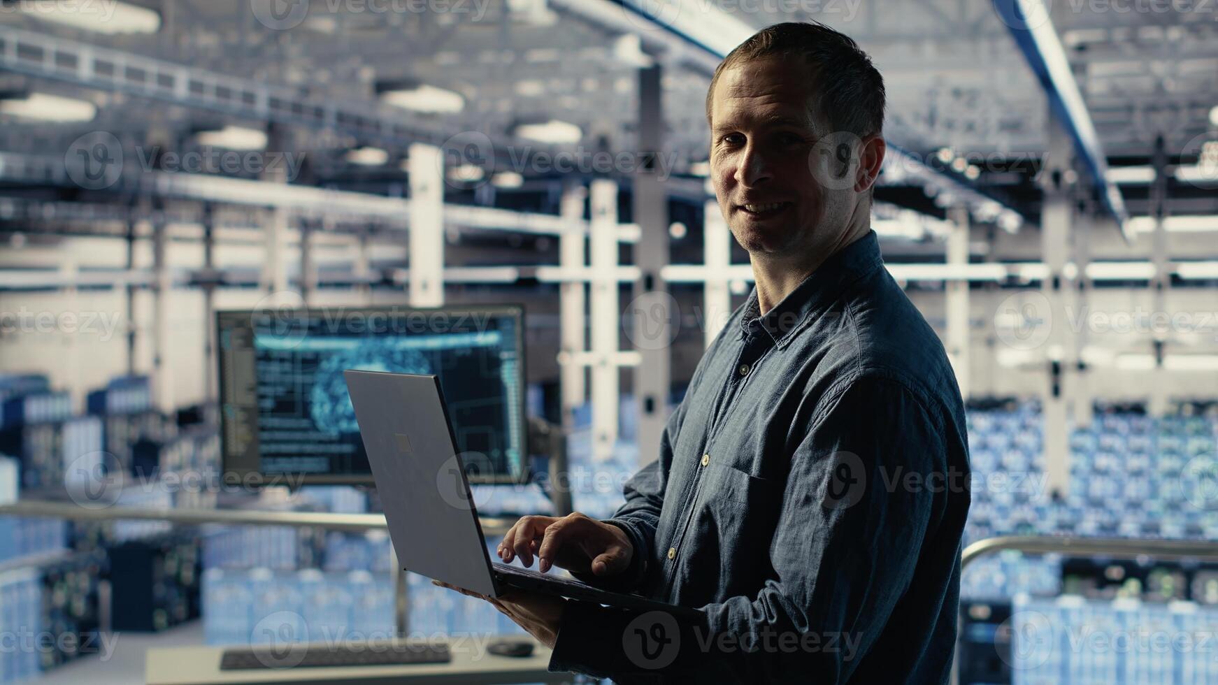 Engineer in data center checks AI dashboard using laptop during routine systems review. IT expert tests artificial intelligence tools on notebook to confirm reliable performance, camera B photo