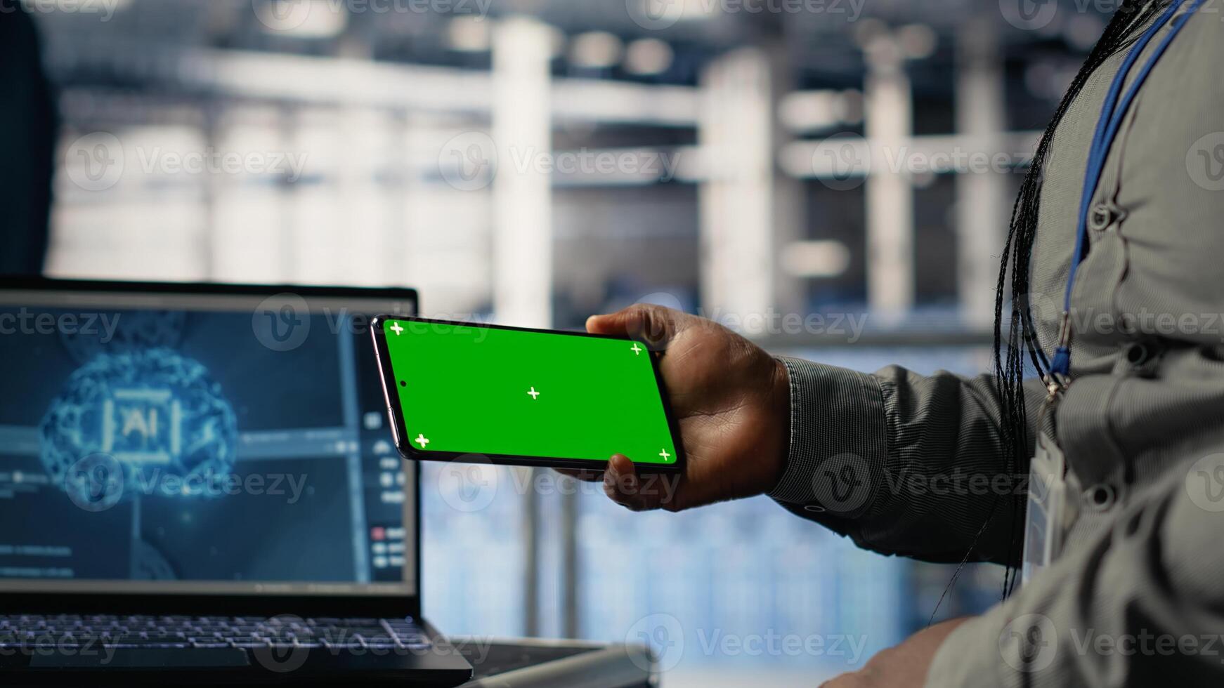 Data center worker uses green screen smartphone while deploying deep learning software. Server hub employee uses mockup mobile phone while training AI systems with datasets photo
