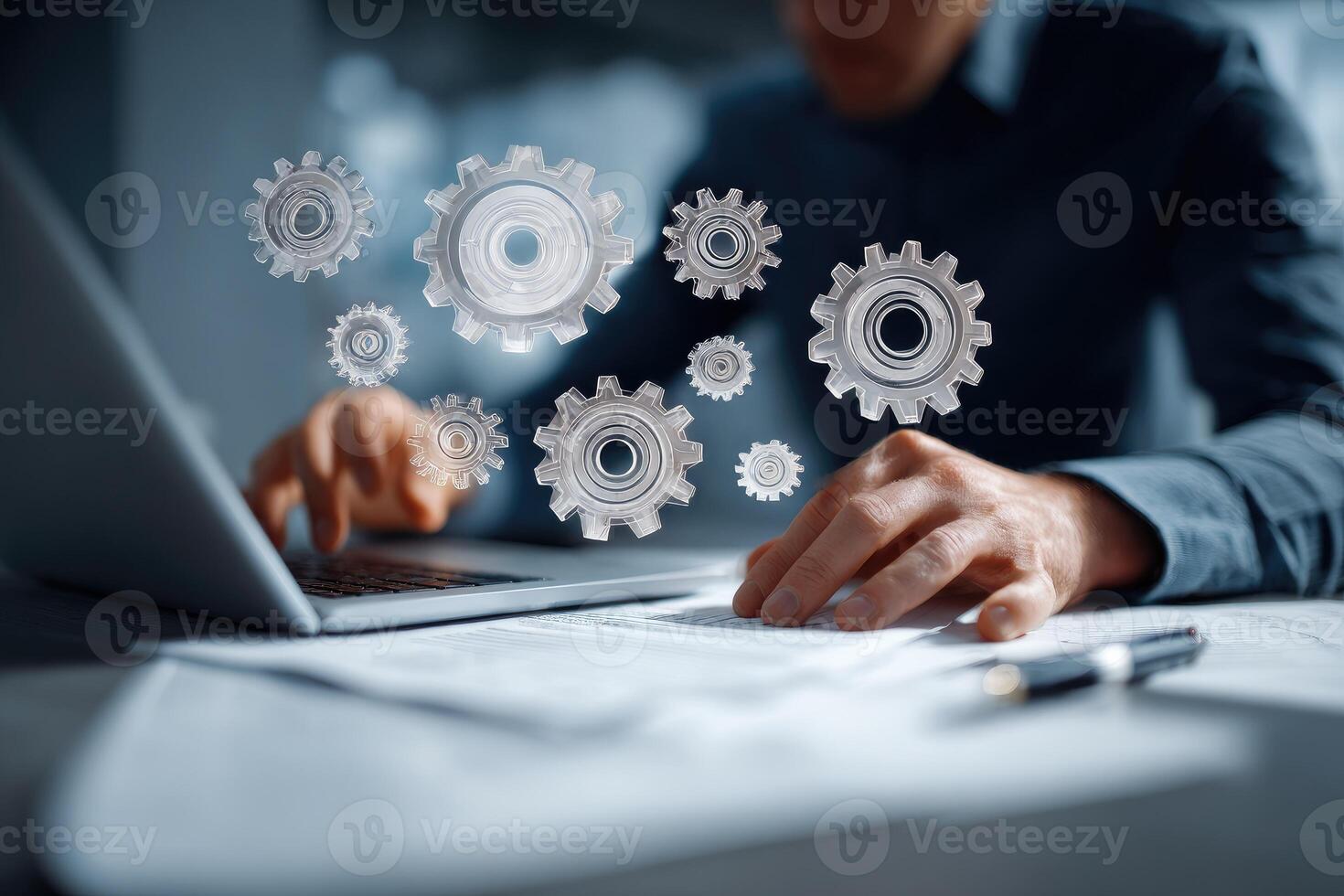 A man is using a laptop with gears on it photo