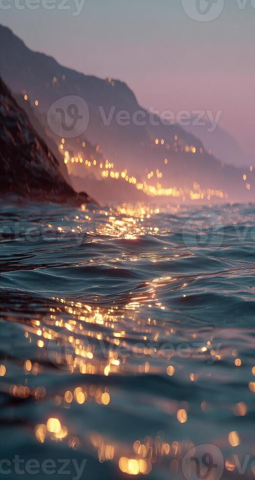 A view of the ocean at dusk with lights shining on it photo