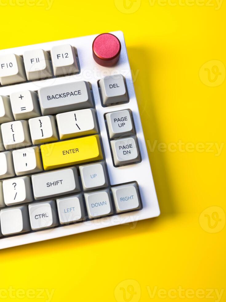 keyboard bright Enter key on bright yellow background, minimalism, keyboard buttons. A keyboard with a yellow key on the bottom left photo