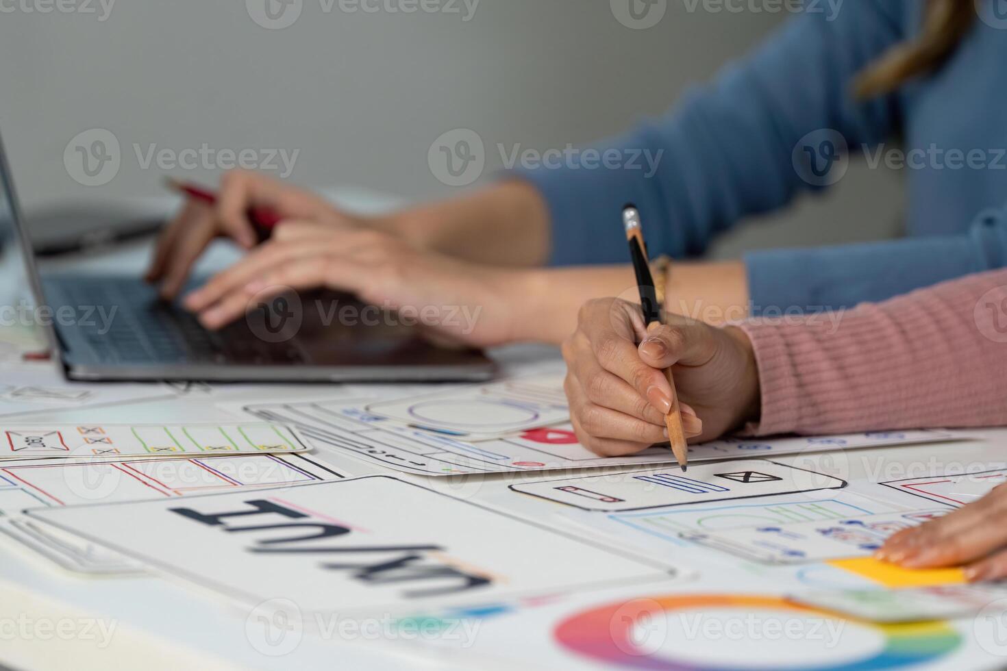 Hands on UX and UI design process with sketches and laptop photo