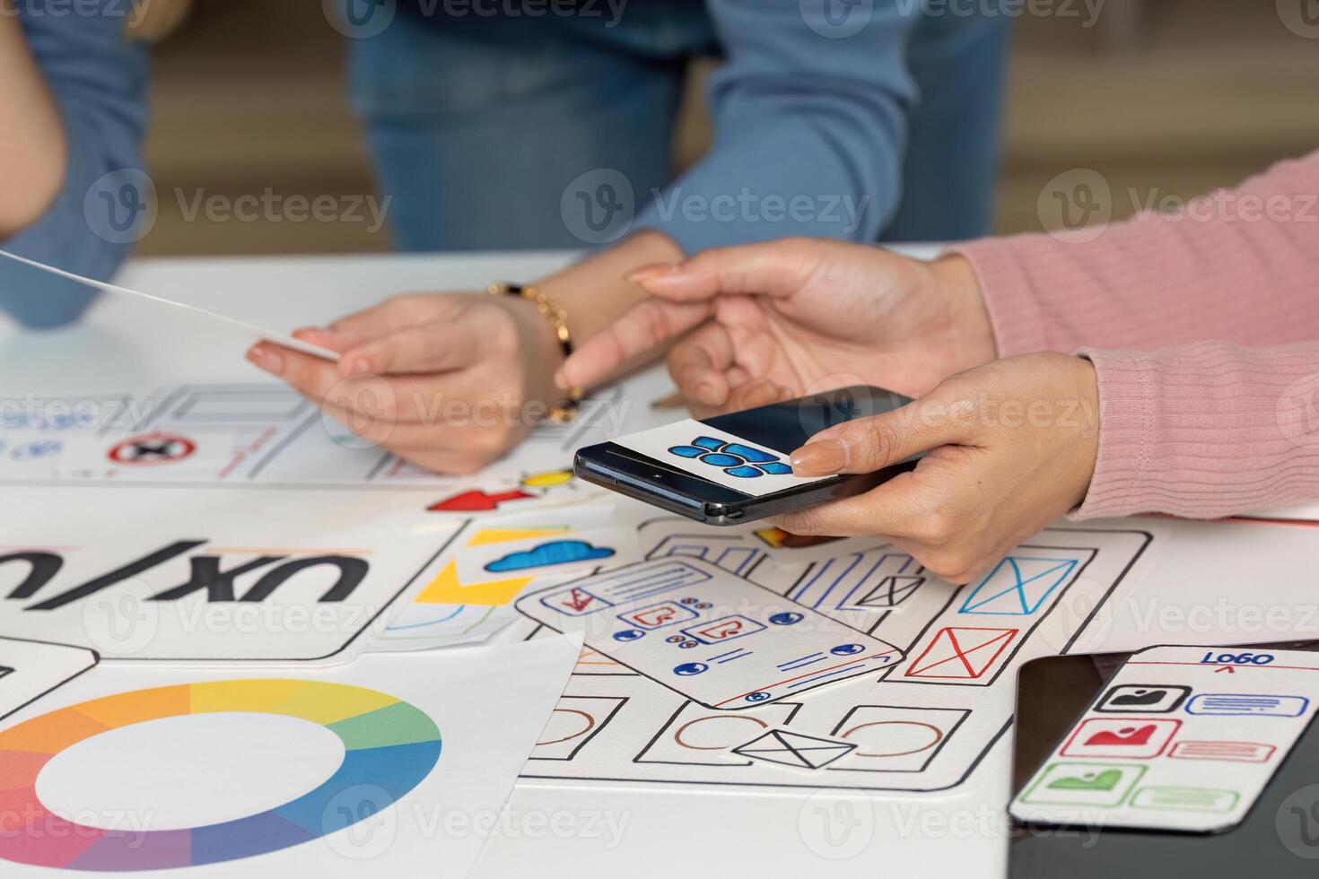 UX and UI Design Team Collaborating with Sketches and Smartphone photo