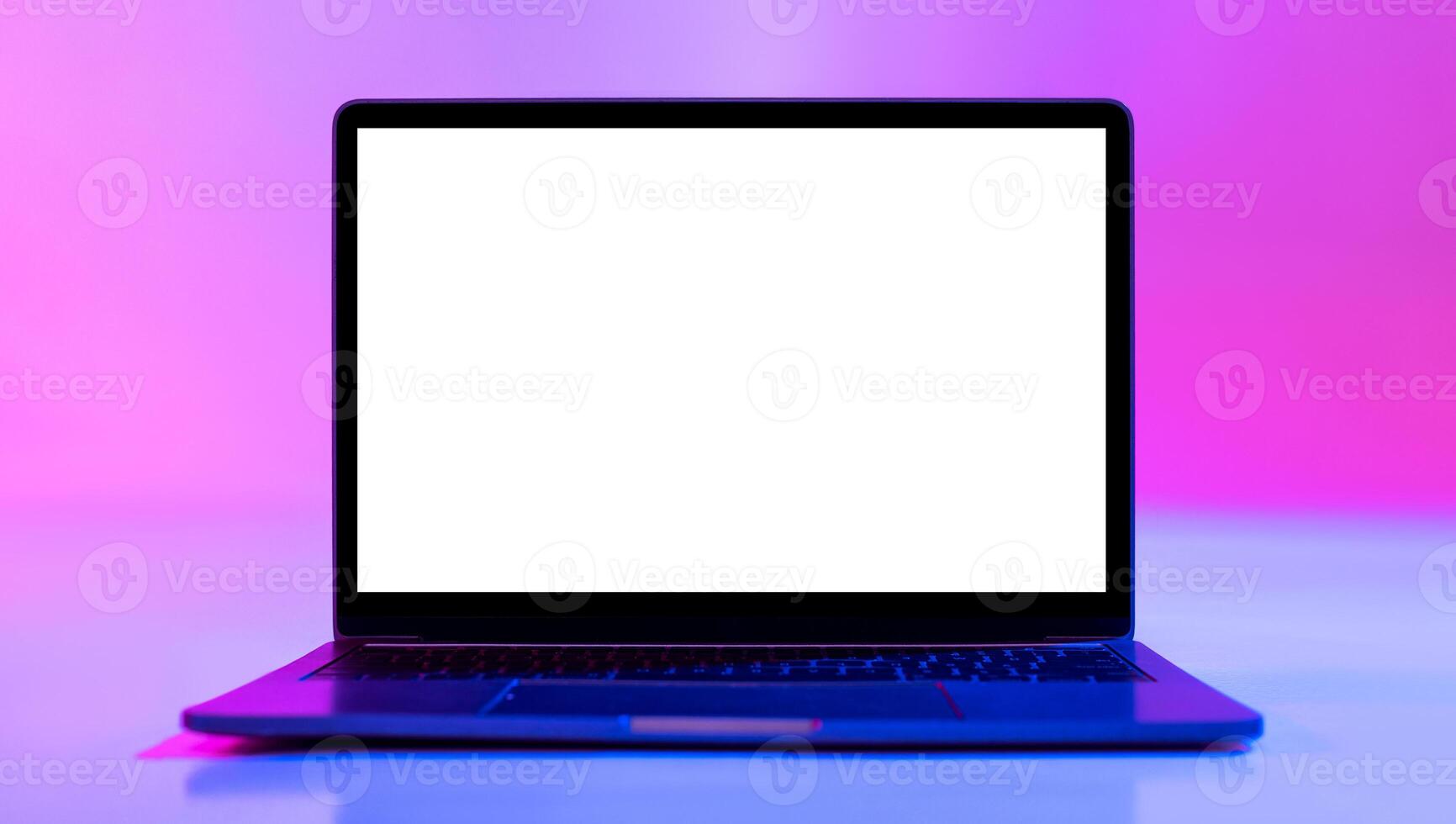Laptop computer with blank white screen in neon light, mockup for desktop or website. Modern portable pc with empty space for your advertisement. Graphic user interface template photo