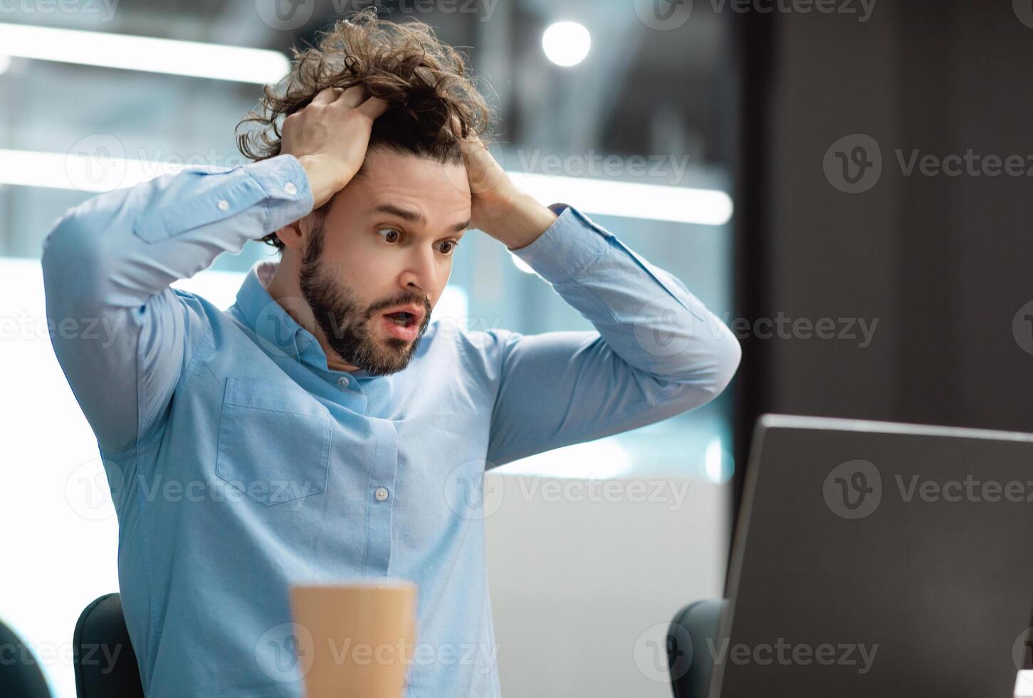 Oh No, Error Concept. Portrait of shocked scared man sitting at desk using pc, gasping with open mouth and grabbing his head. Stressed worried man suffering business problems reading bad negative news photo