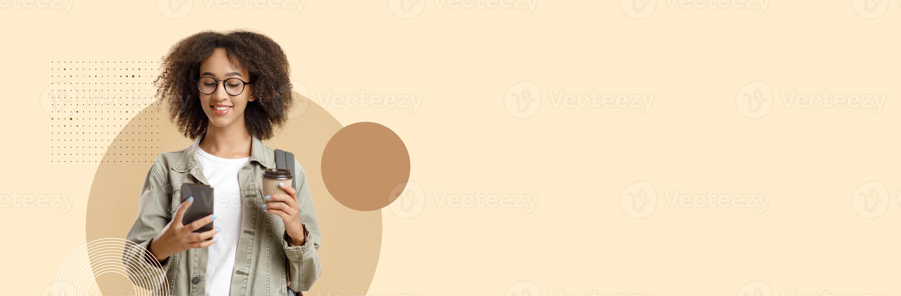 A student smiling while using a smartphone in a casual educational setting. She holds a coffee cup, embodying the new normal of learning and connectivity in college life. photo