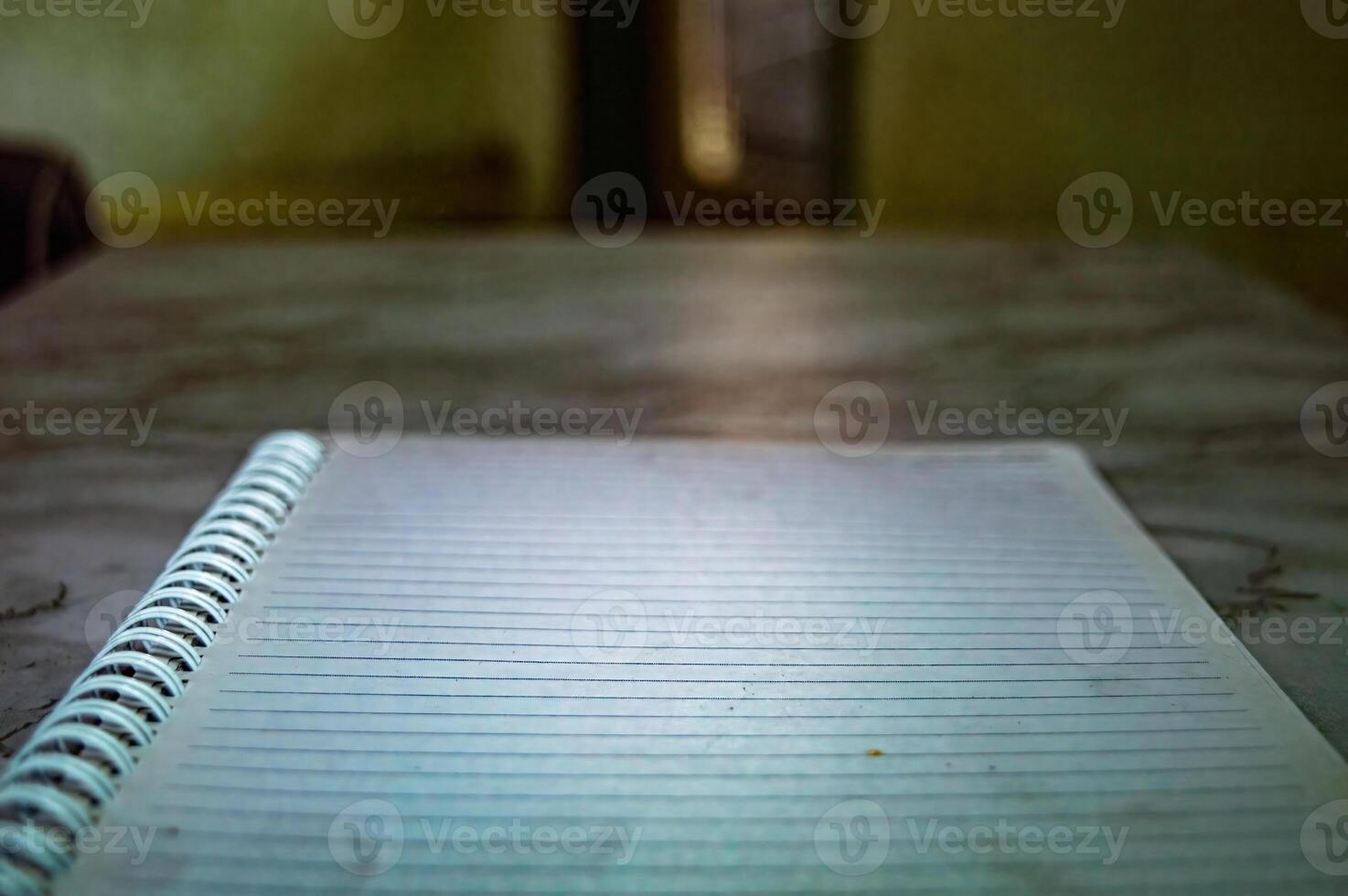 Close up of a spiral notebook with lined paper on a table, showing a simple and functional design for writing, journaling, or note taking in a home or office setting photo