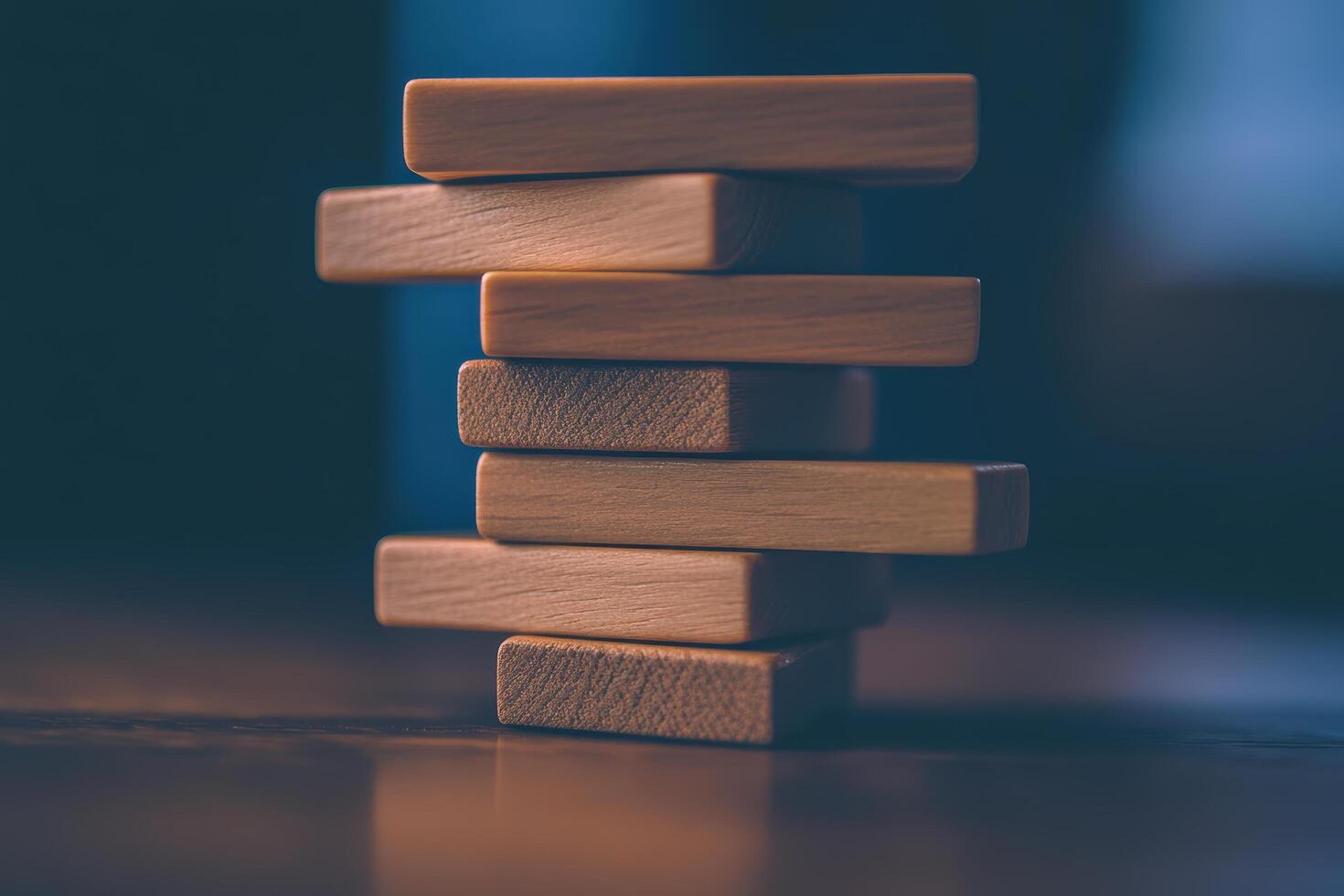 Stacked wooden blocks create a balanced tower on a wooden table photo