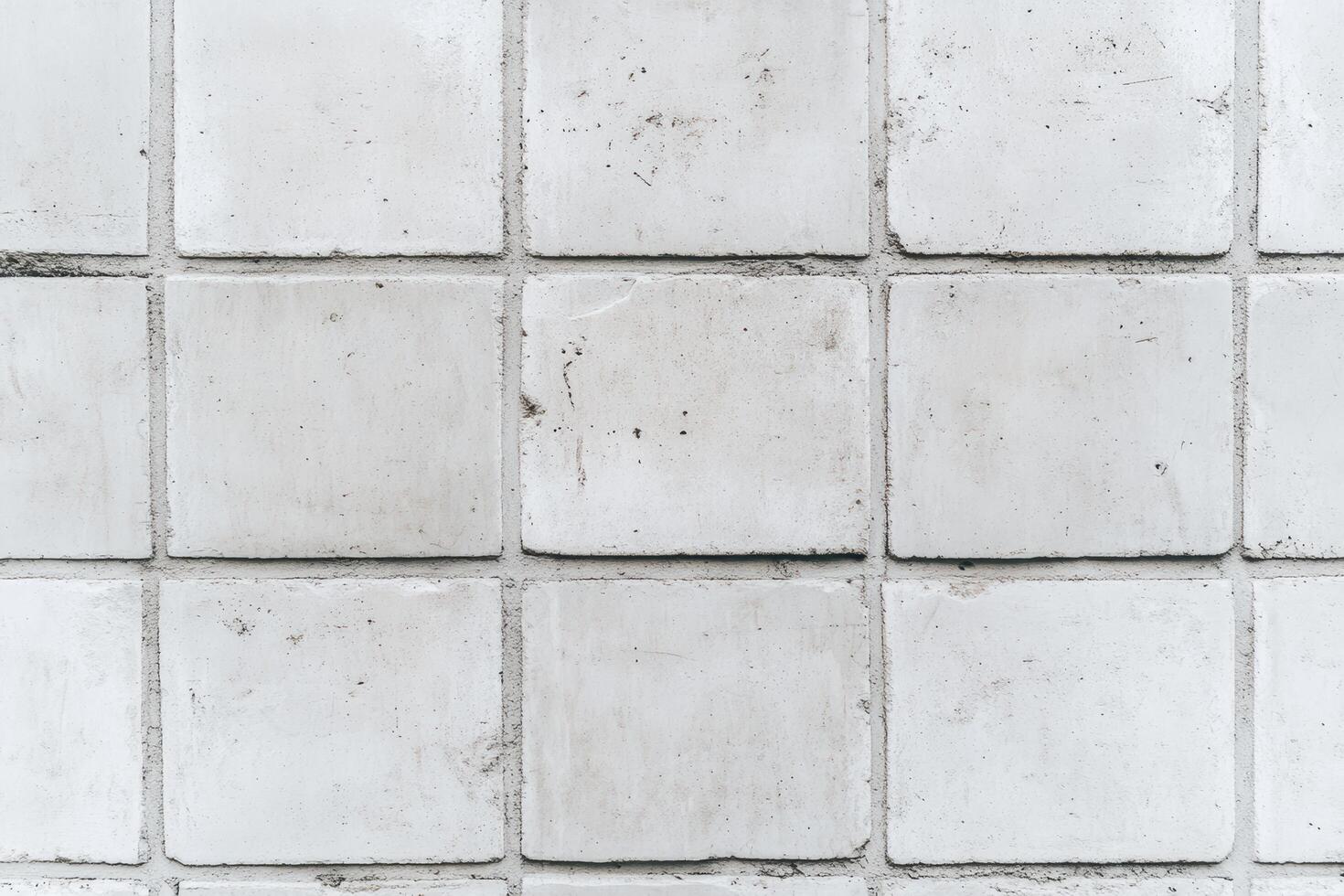 Concrete tile wall with square patterns showing wear and texture photo