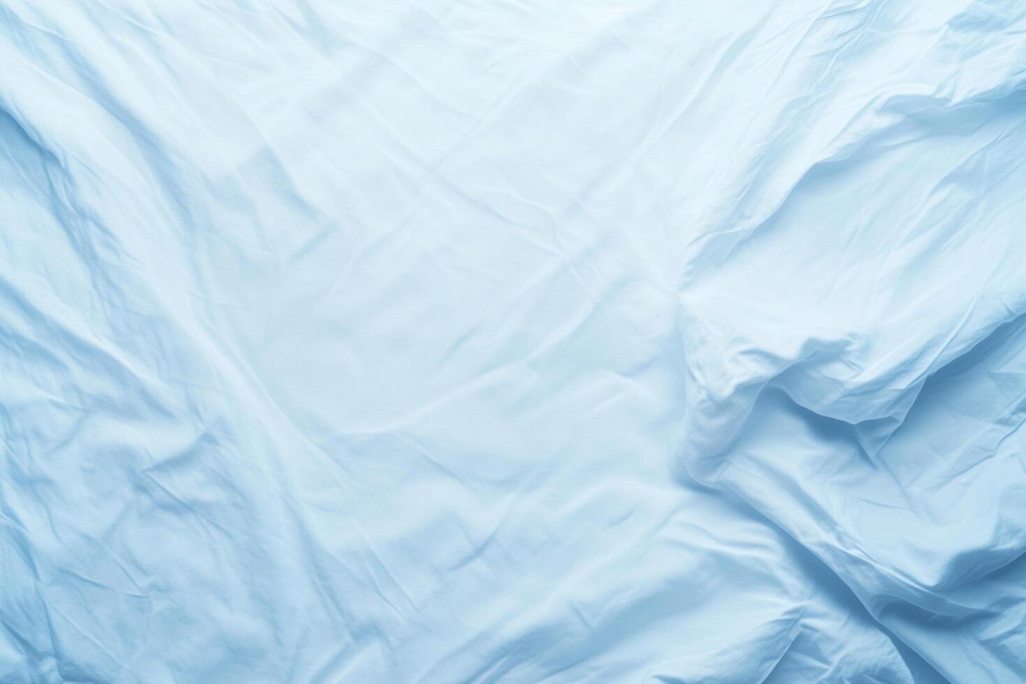 Bright blue wrinkled fabric draped on a surface creating a soft texture photo