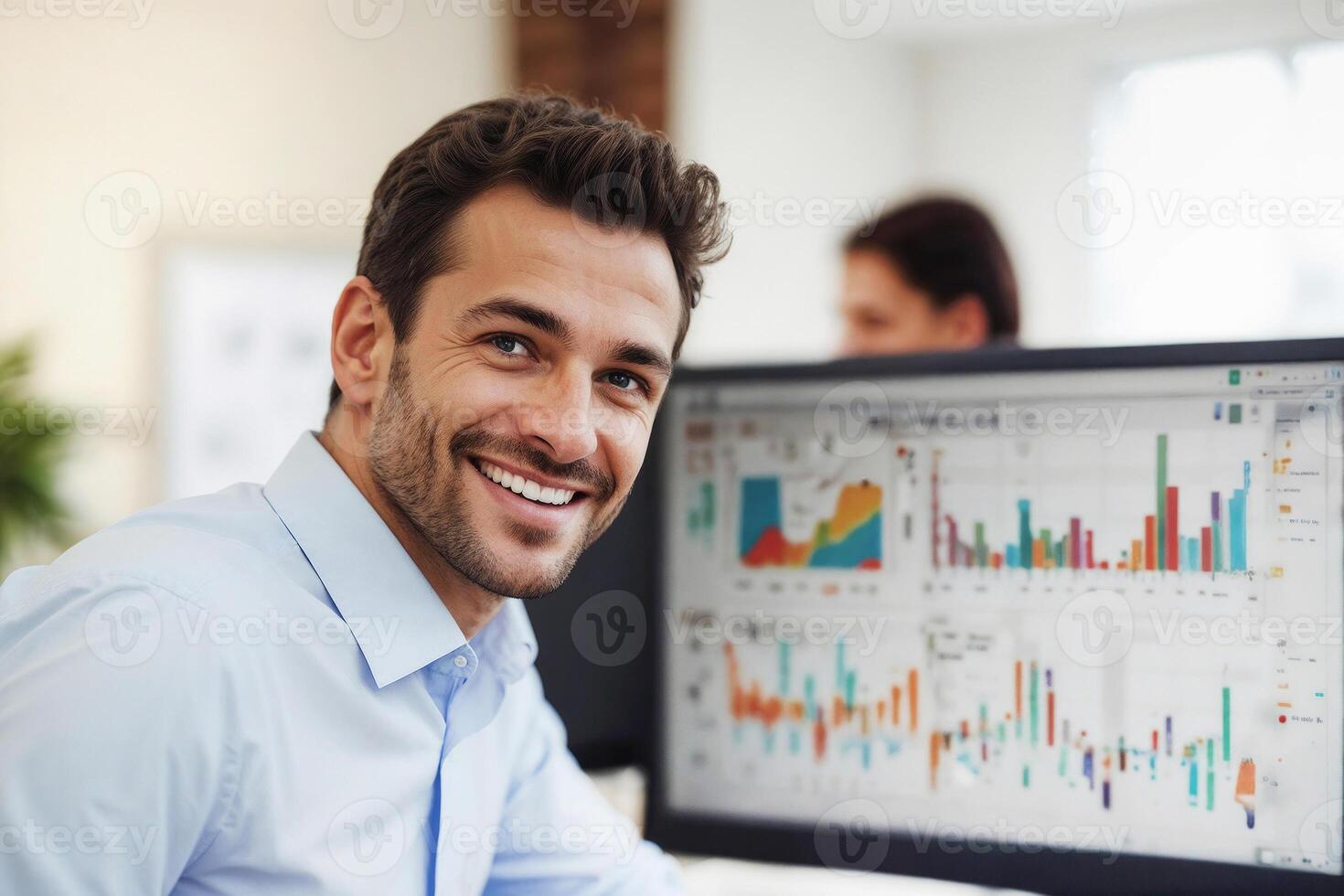 Businessman is smiling in front of a computer monitor with charts in office photo