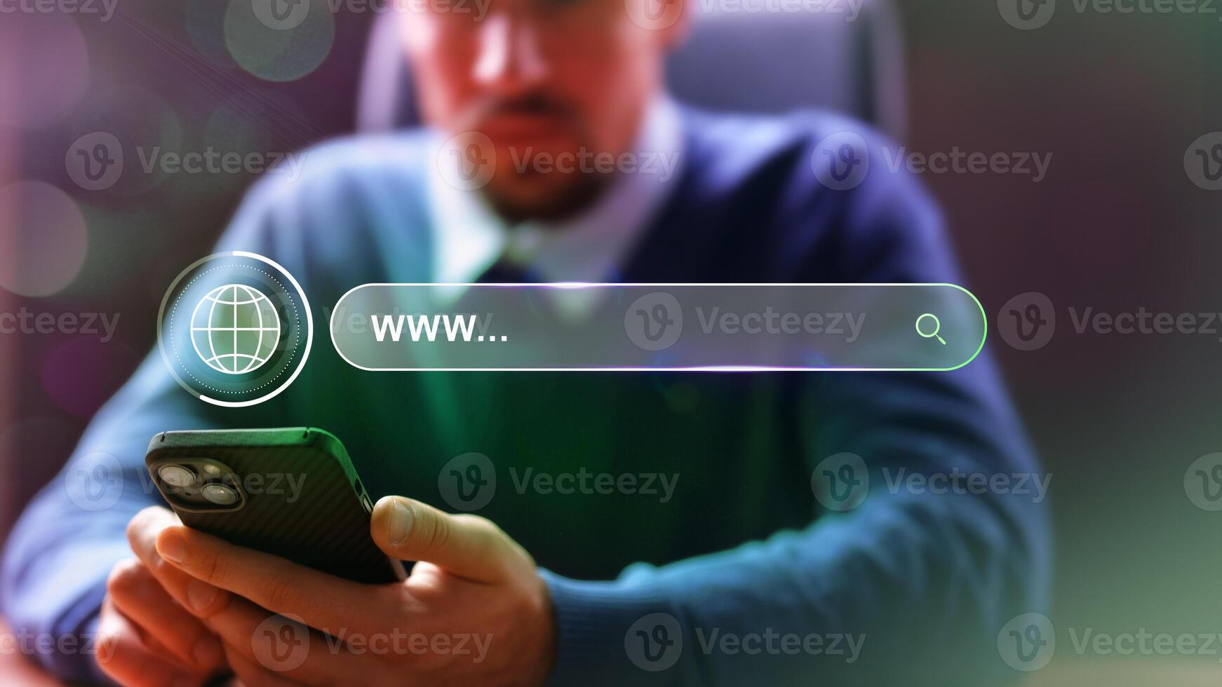 Man browses the internet on a smartphone while seated in an office environment focusing on online resources photo