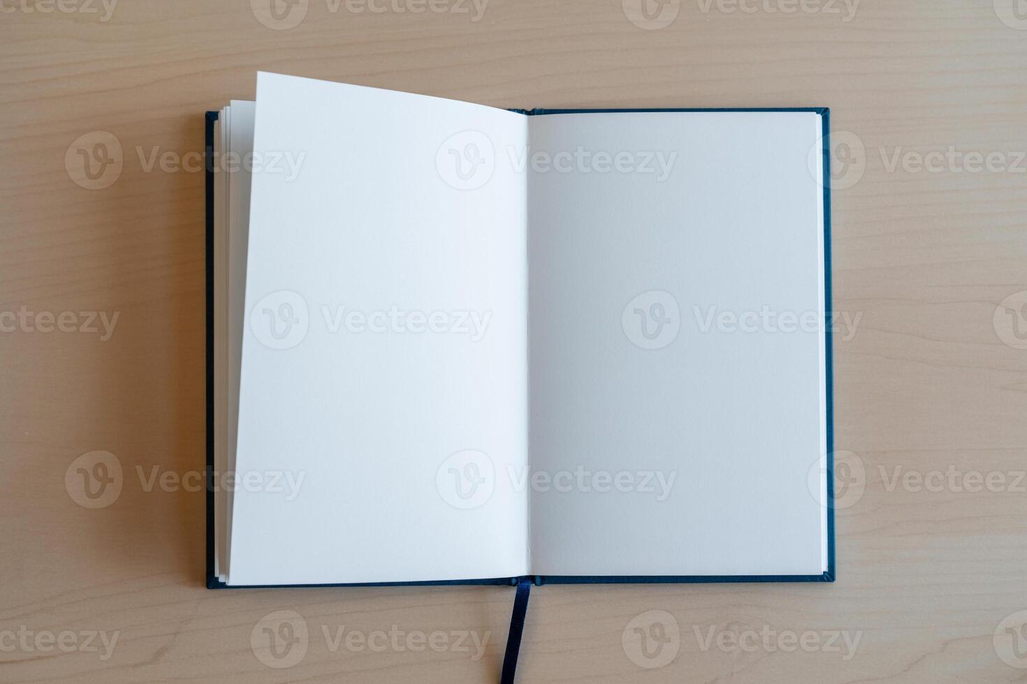 Blank notebook with open pages on wooden desk, ready for ideas and notes, representing new beginnings and potential photo