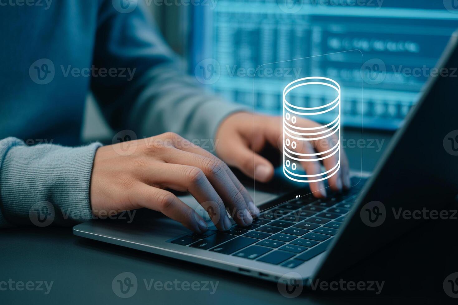 Person working diligently on laptop computer, managing a database at night in a modern office, symbolizing data management and cybersecurity photo