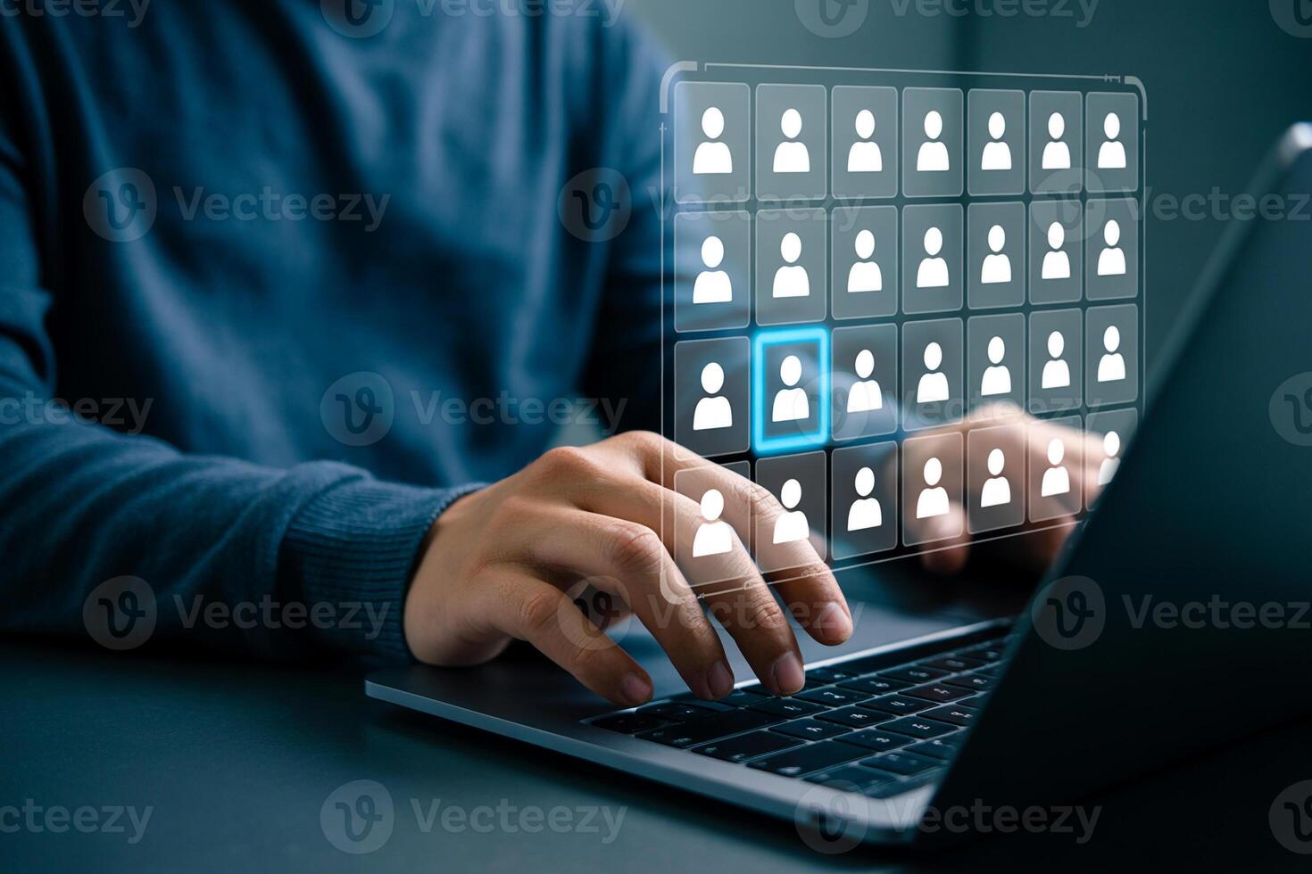 Person using laptop computer to select a candidate from a digital grid of profiles, conducting a meticulous online recruitment process in a modern office setting photo