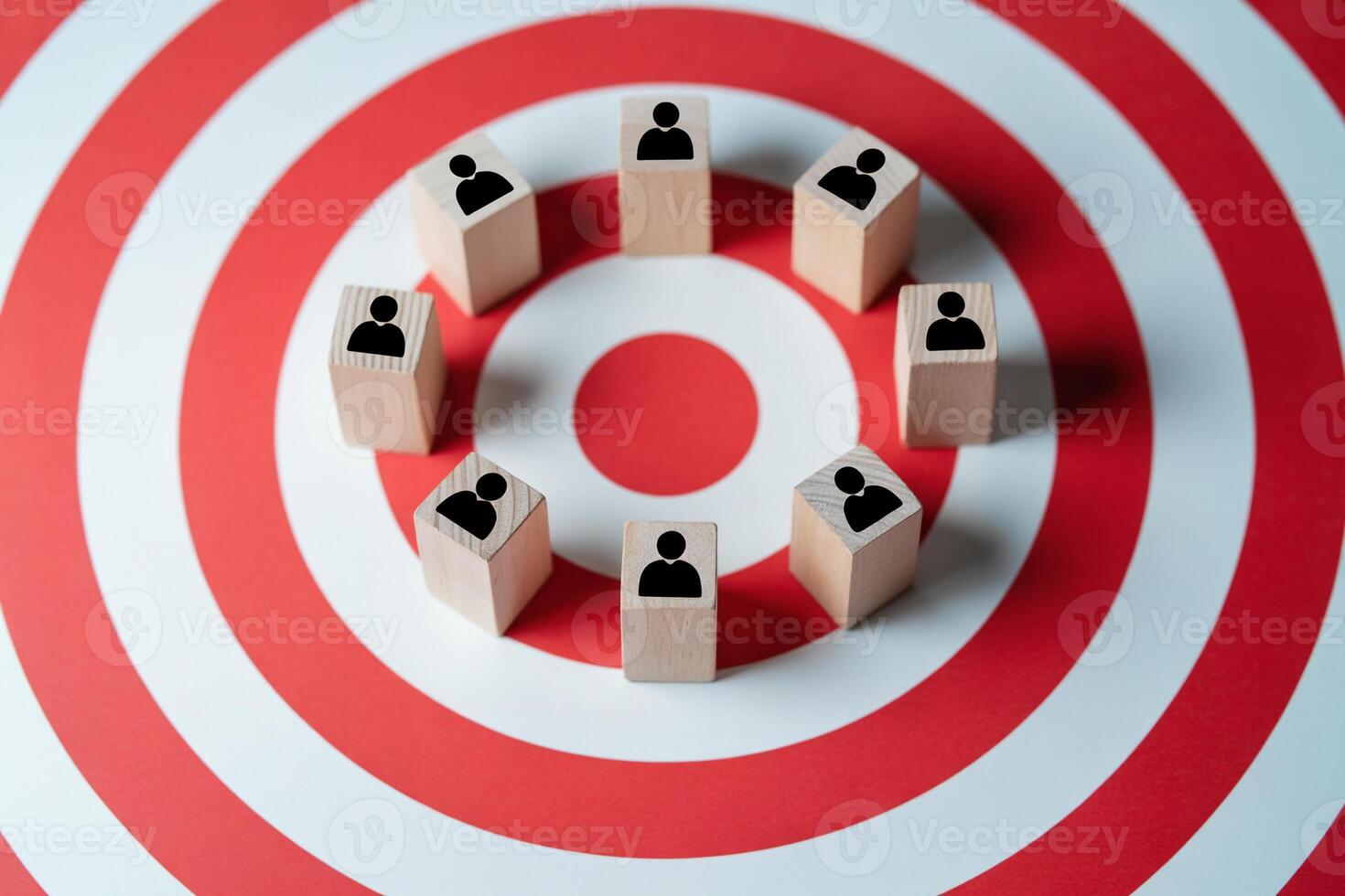 Teamwork and collaboration on target Wooden blocks with people icons arranged in a circle on a red and white target background, symbolizing successful team goal achievement and str photo