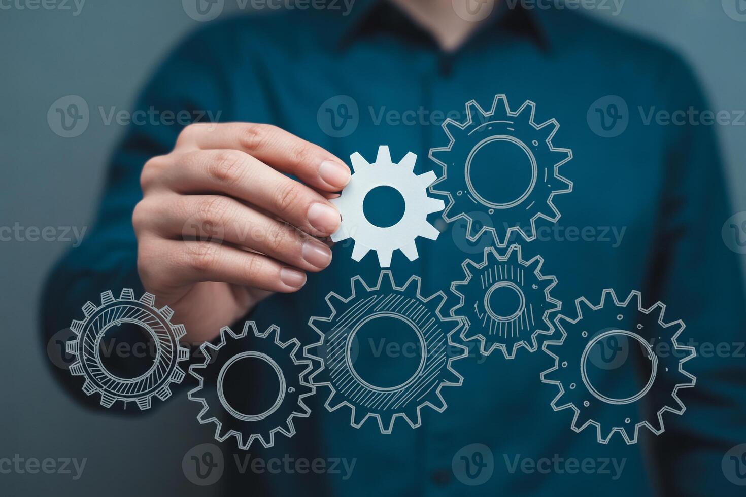 Person connecting gears mechanism, a process of teamwork and collaboration, in a modern business setting, symbolizing efficiency and strategic planning photo